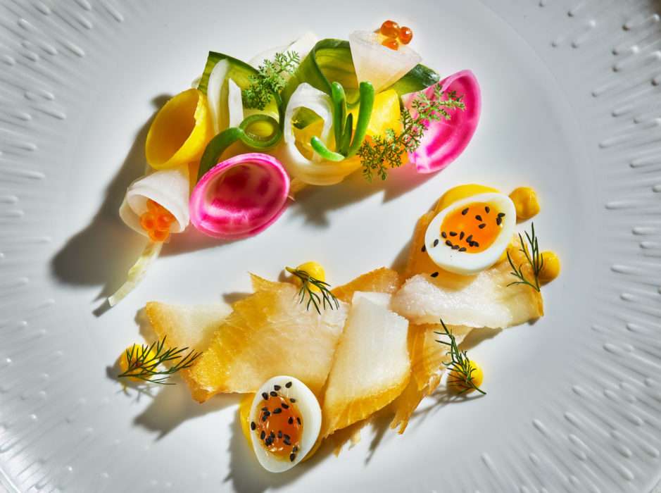 Smoked Halibut with quail egg, pickled beetroot, shaved fennel on white patterned plate.
