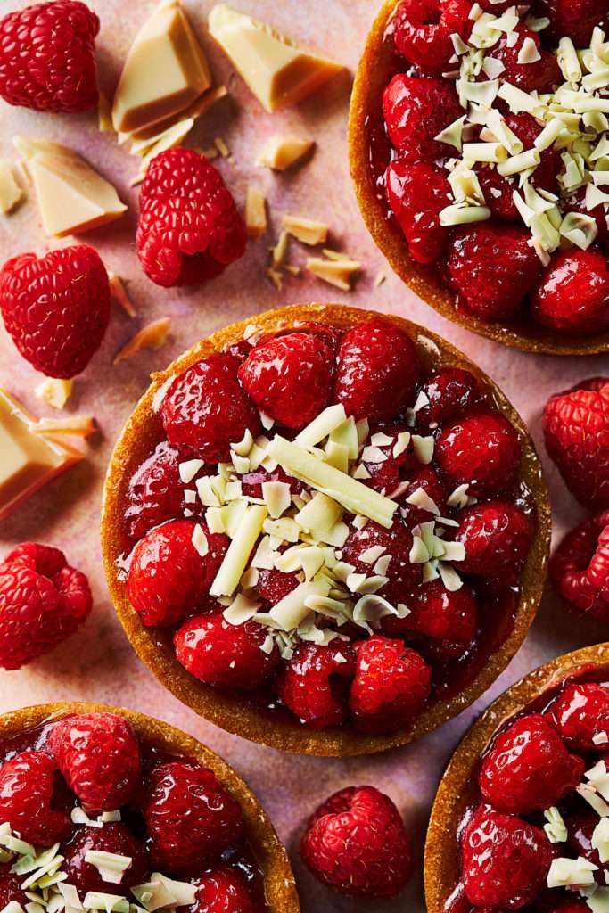 Photo of Raspberry Tart, overhead, with white chocolate shavings by London food photographer, Michael Michaels